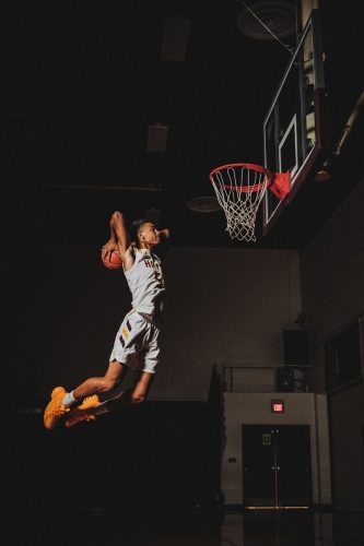 2 boys playing basketball on basketball court